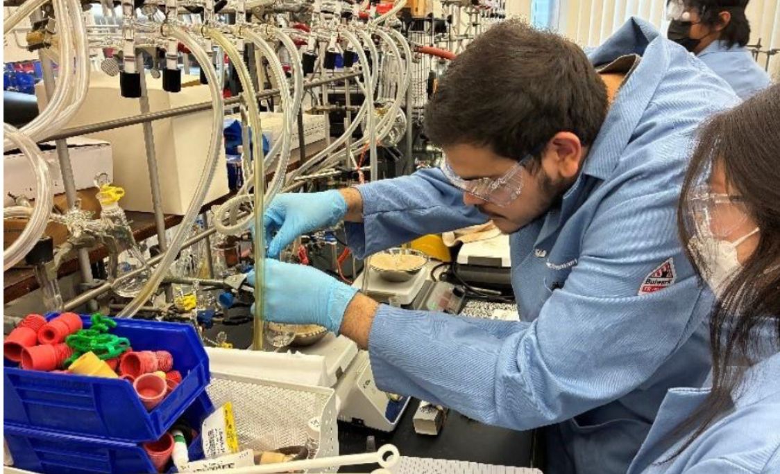 student lab technician working on lab equipment