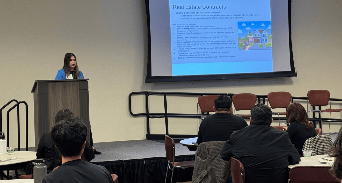 alumna presenting to students on stage