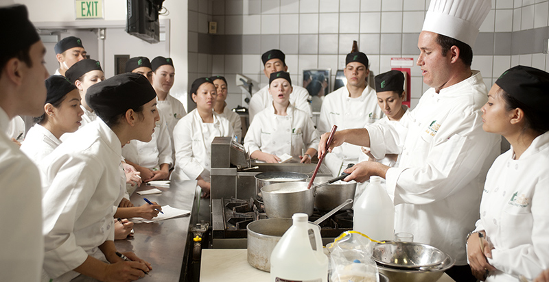 Alumnus teaching a cooking class.