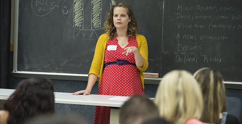 An alumni at the front of class speaking to students