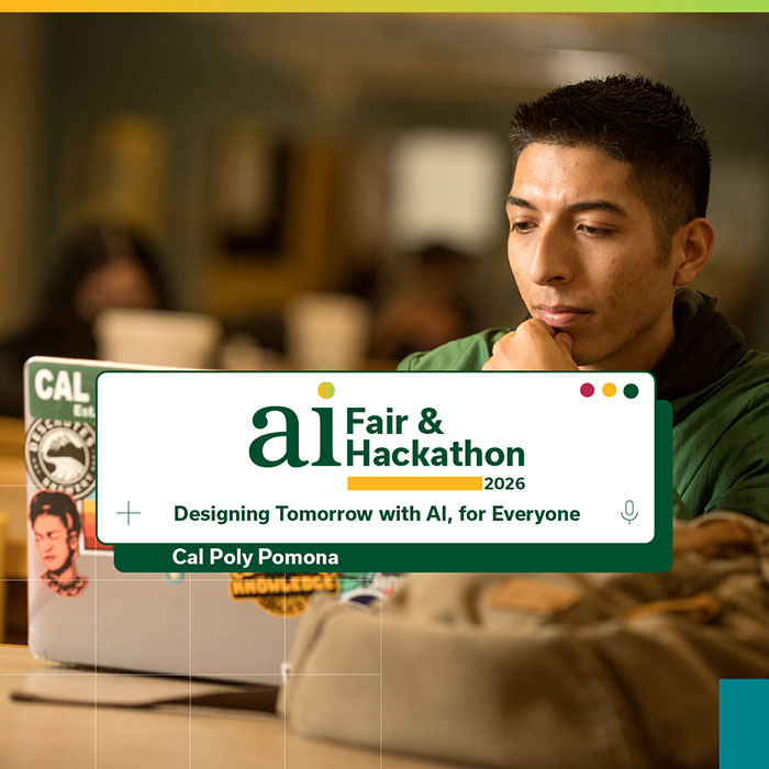 A student sitting at a table looks at their laptop