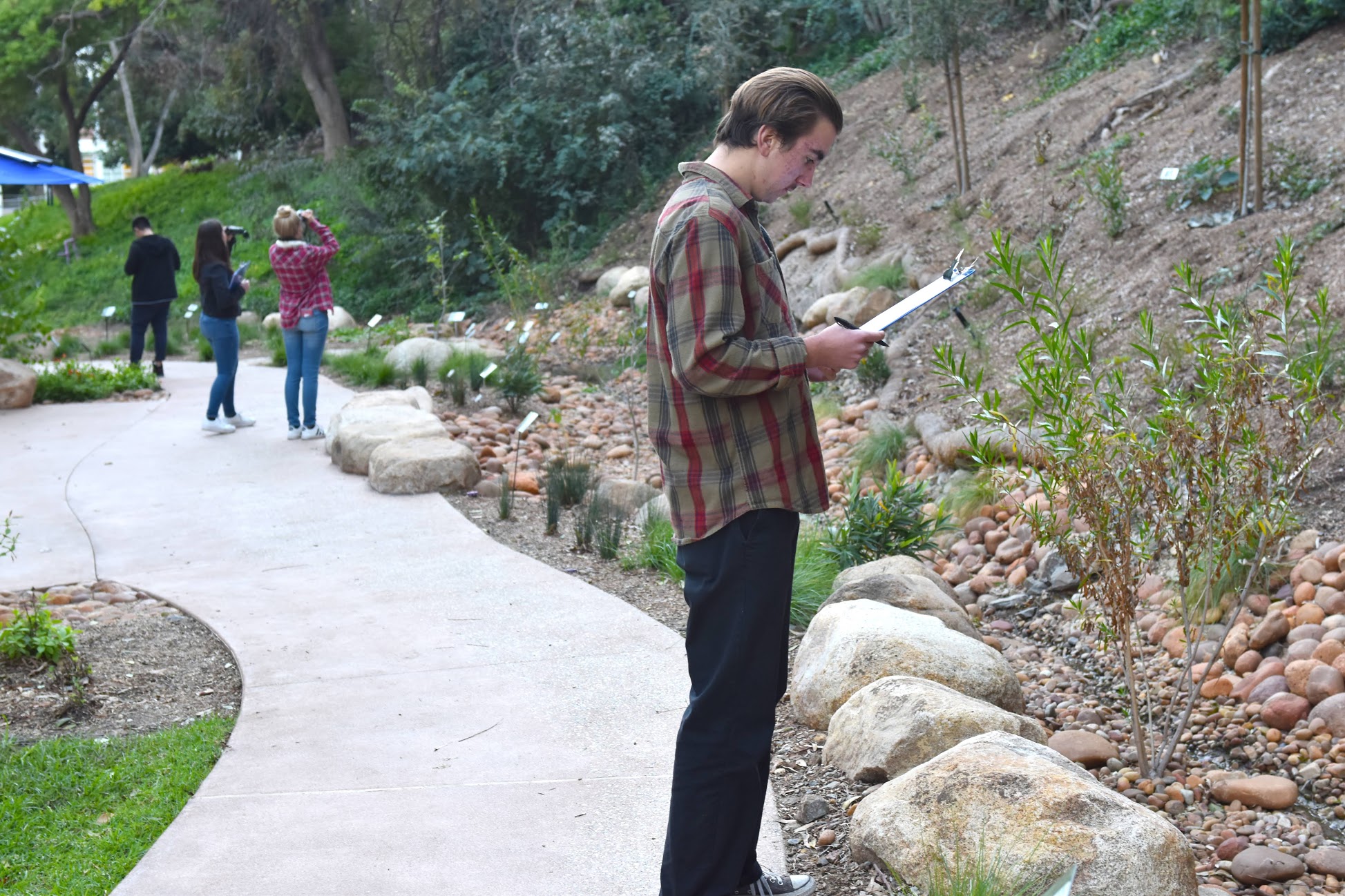 student observing and  holding a clip board