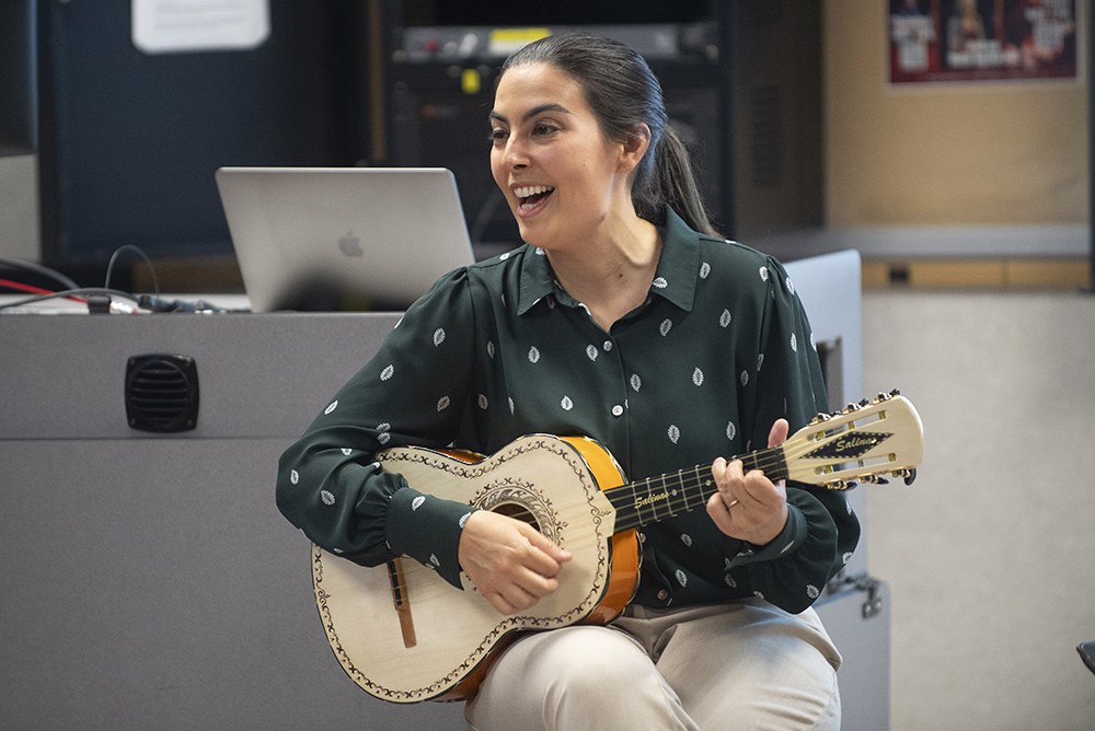 Jessie Vallejo playing guitar in the classroom for her students