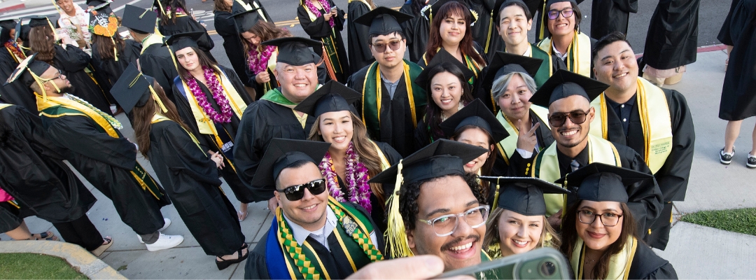 A group of graduating students take a selfie with the camera