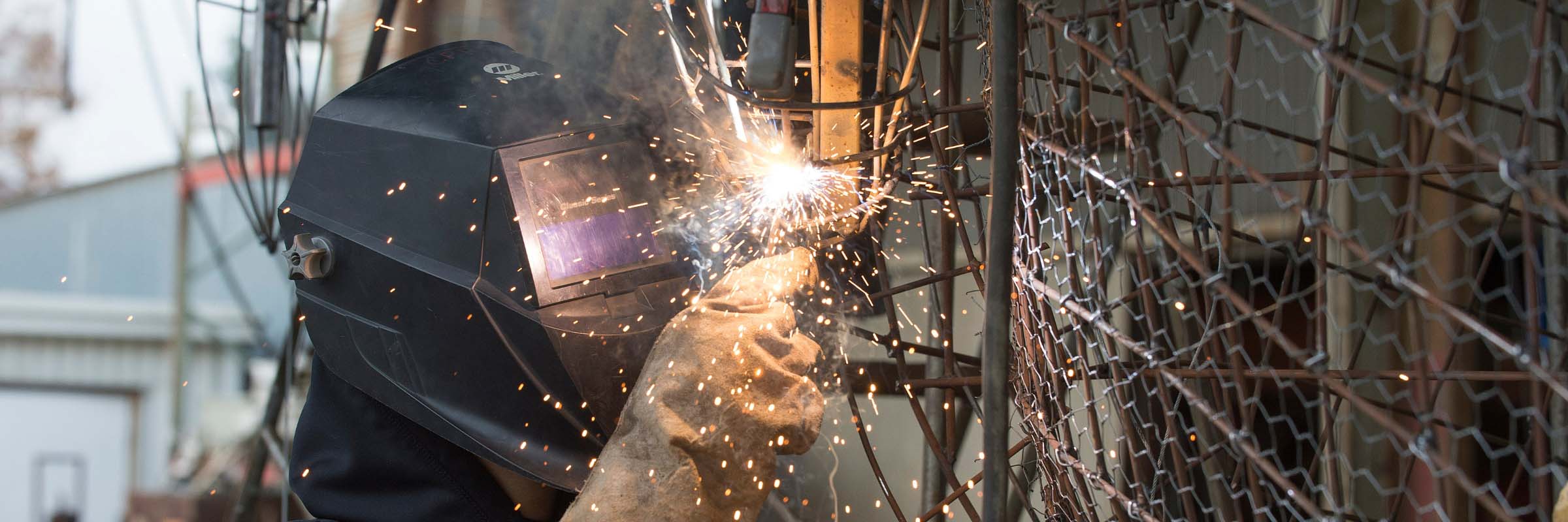 A student welds a piece of the Rose Float frame