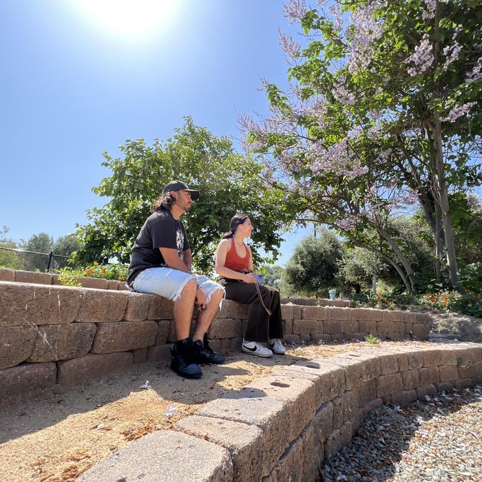 Two students sitting outdoors at the Lyle Center outdoor classroom space