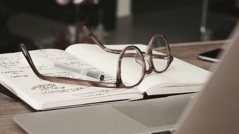 Closeup of eyeglasses sitting on an open book