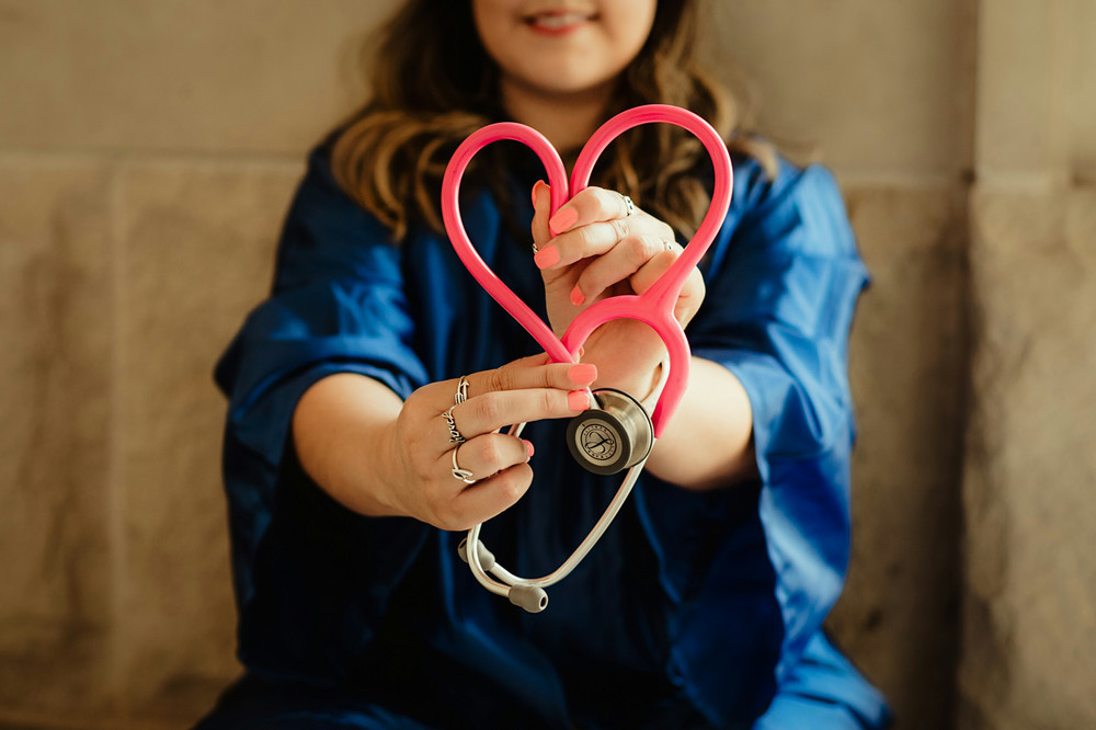 “Person holding a pink stethoscope in a heart shape