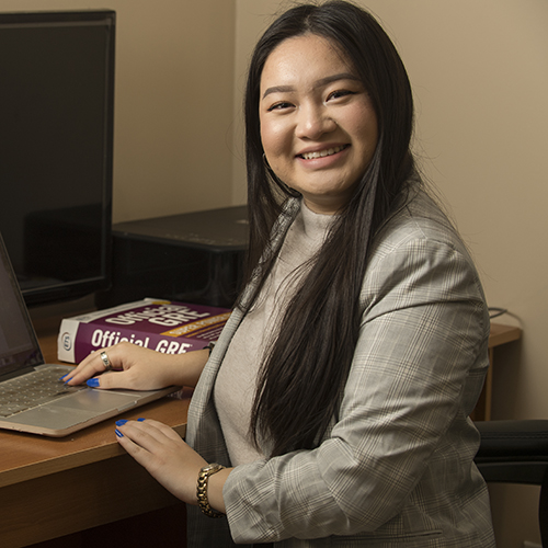 Kelly Nguyen in standing by desk