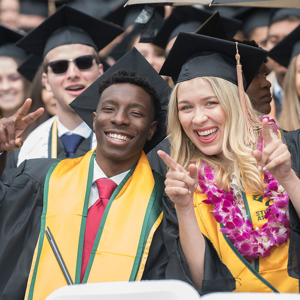 two students smiling at camera during Commencement
