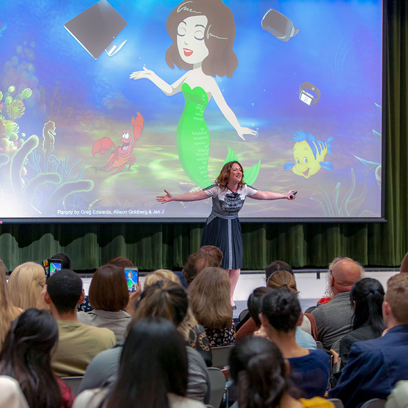 Randi Zuckerberg sings on stage during her Dean's Leadership Forum