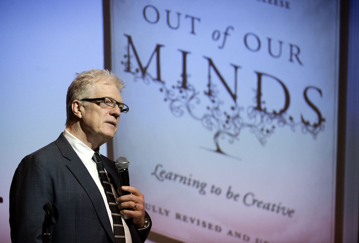 Robinson at his leadership forum with picture of his book Out of Our Minds in the background