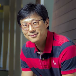 Professor Joonho Lee sitting on bench in CBA hall