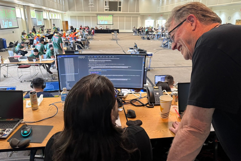 Prof. helping students at CPP WRCCDC cybersecurity competition 