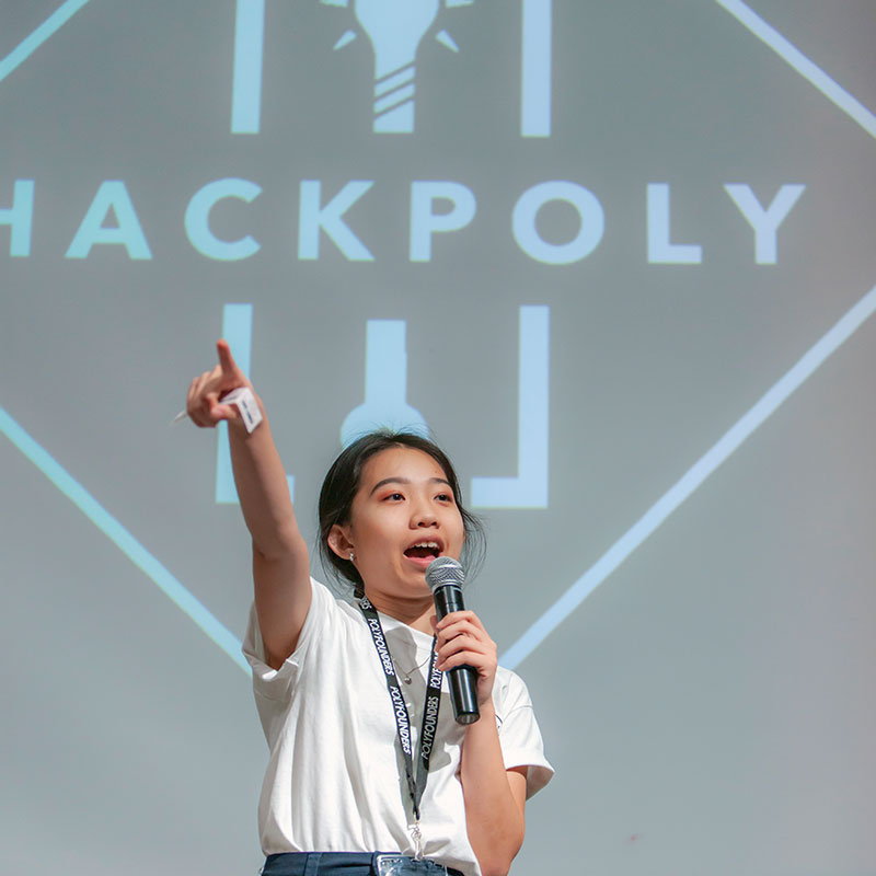 Announcer with microphone on stage during Hackpoly