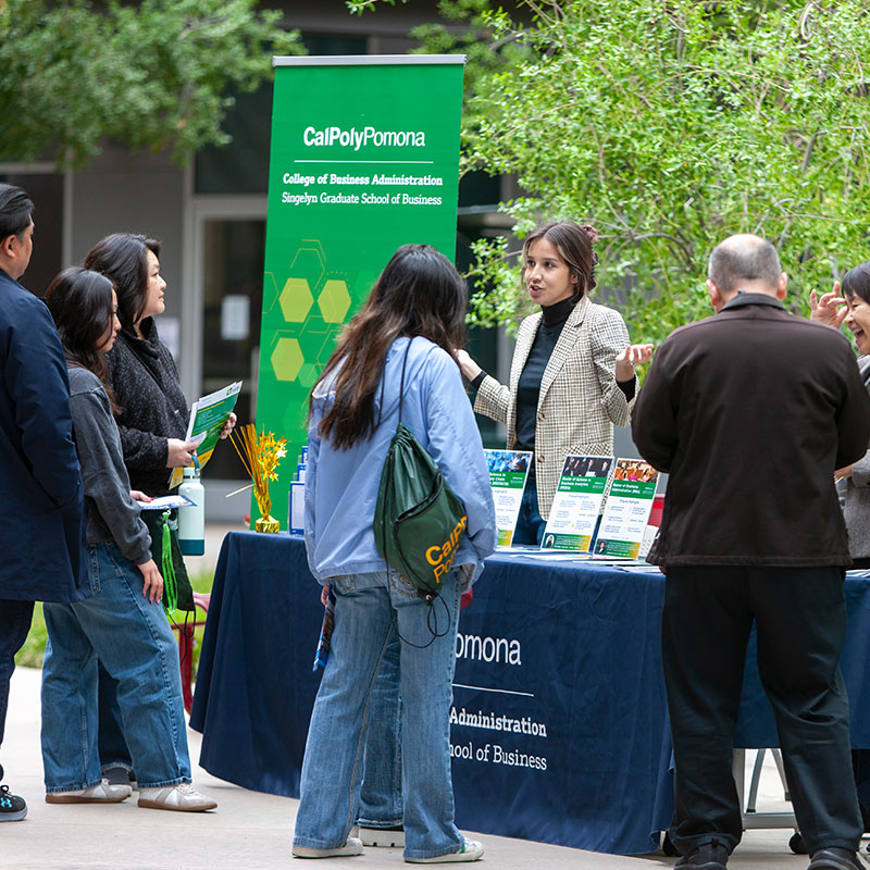 Advisor welcoming future students in the CBA courtyard