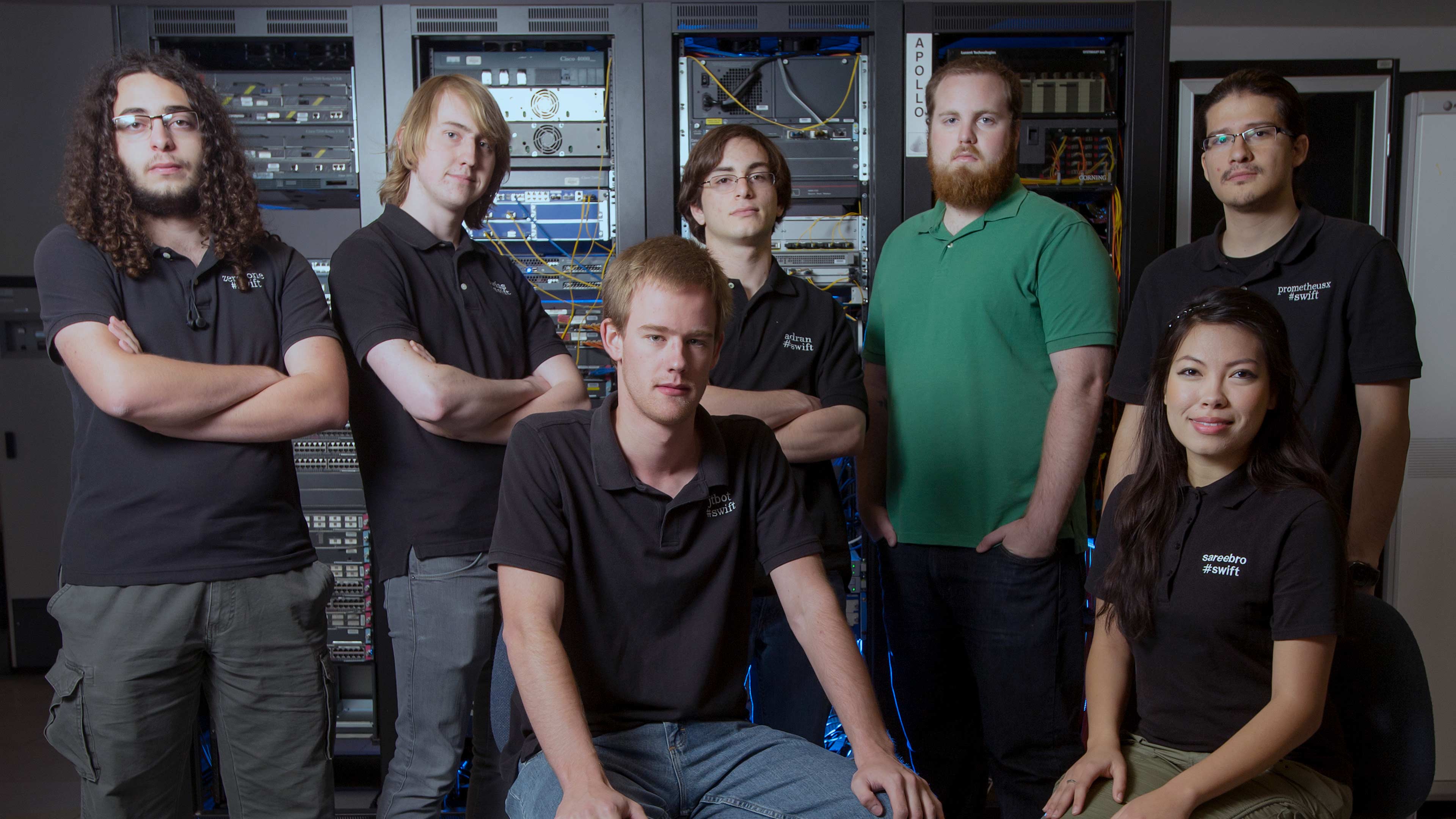 Group of students sitting in data center with servers in back