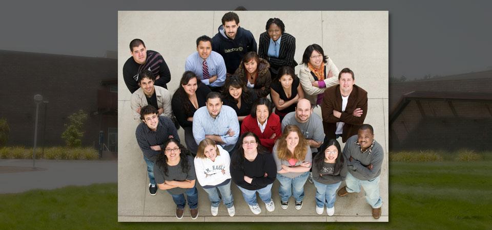 Group of students looking up toward camera with CBA building in background