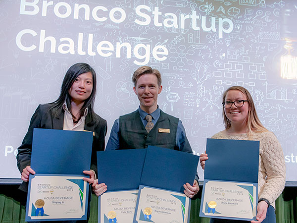 Members of AZUZA Beverage hold winners certificates on stage during Bronco Startup Challenge