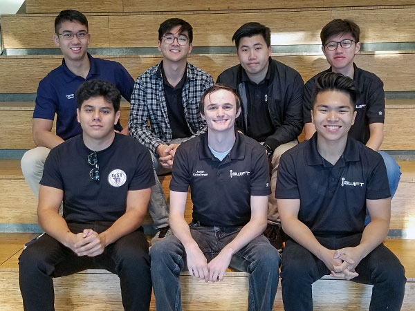 7 male students on benches during competition