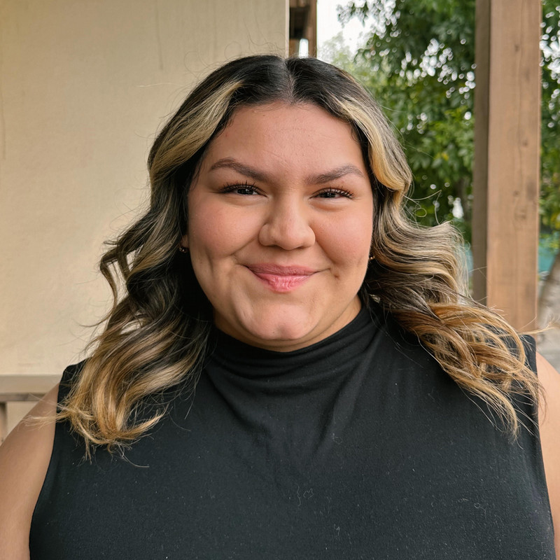 Kyra Garza a woman wearing a short-sleeved turtle neck top