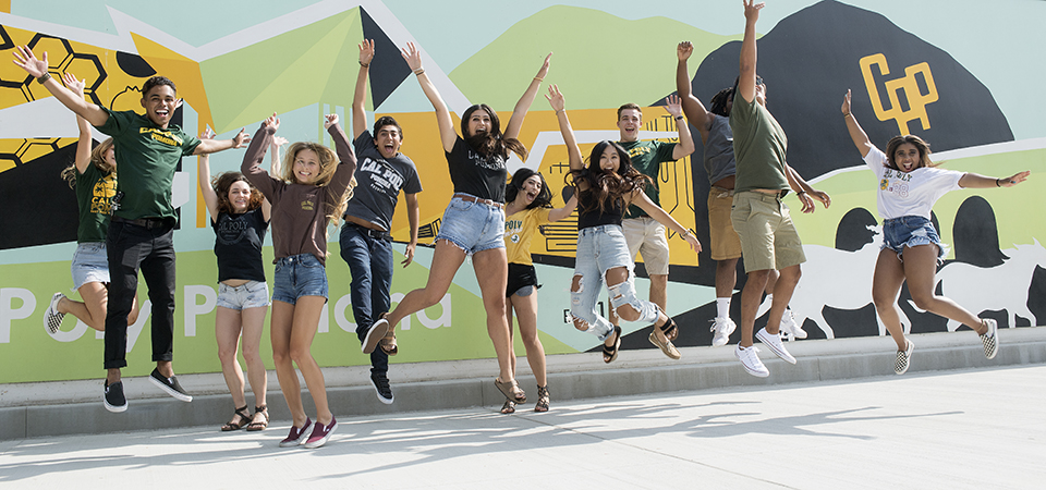 student jumping in front of mural