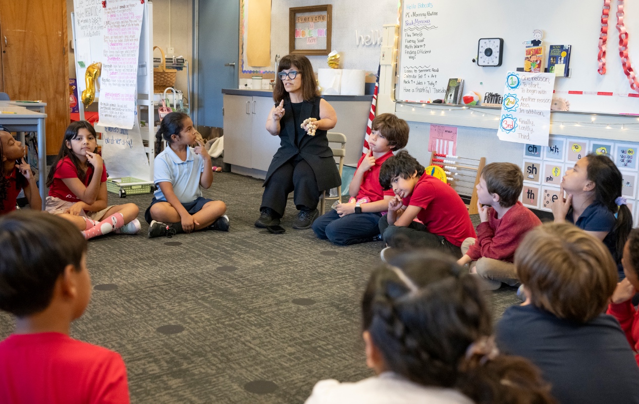teacher teaching students in elementary in a classroom. 