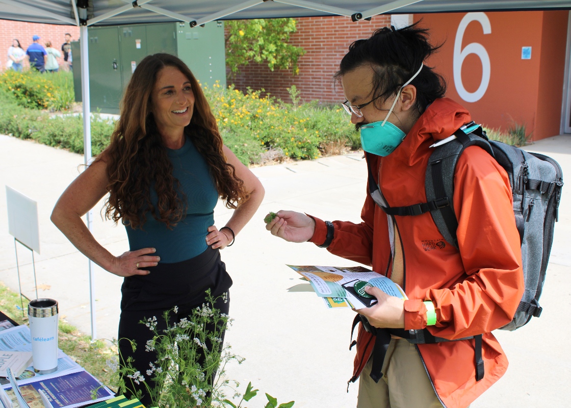 Dr. Teresa Lloro with a student and a CEIS Event discussing the sustainability minor. 