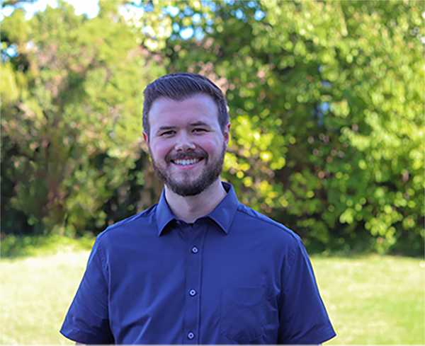 image of andrew smiling in a blue shirt