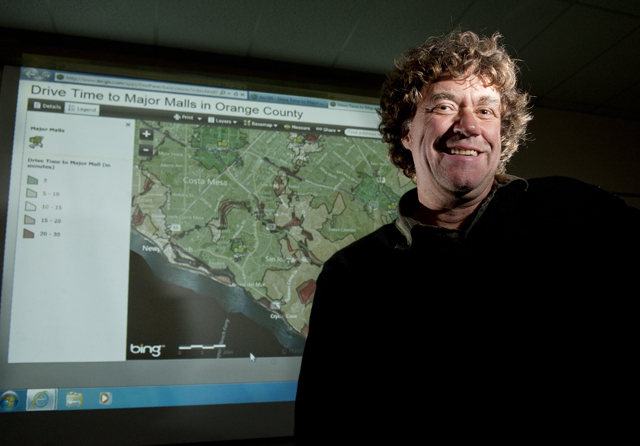 Dr. Carsten Lange smiling next to projector screen