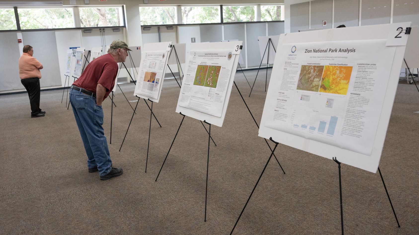 map posters displayed on easels with onlookers