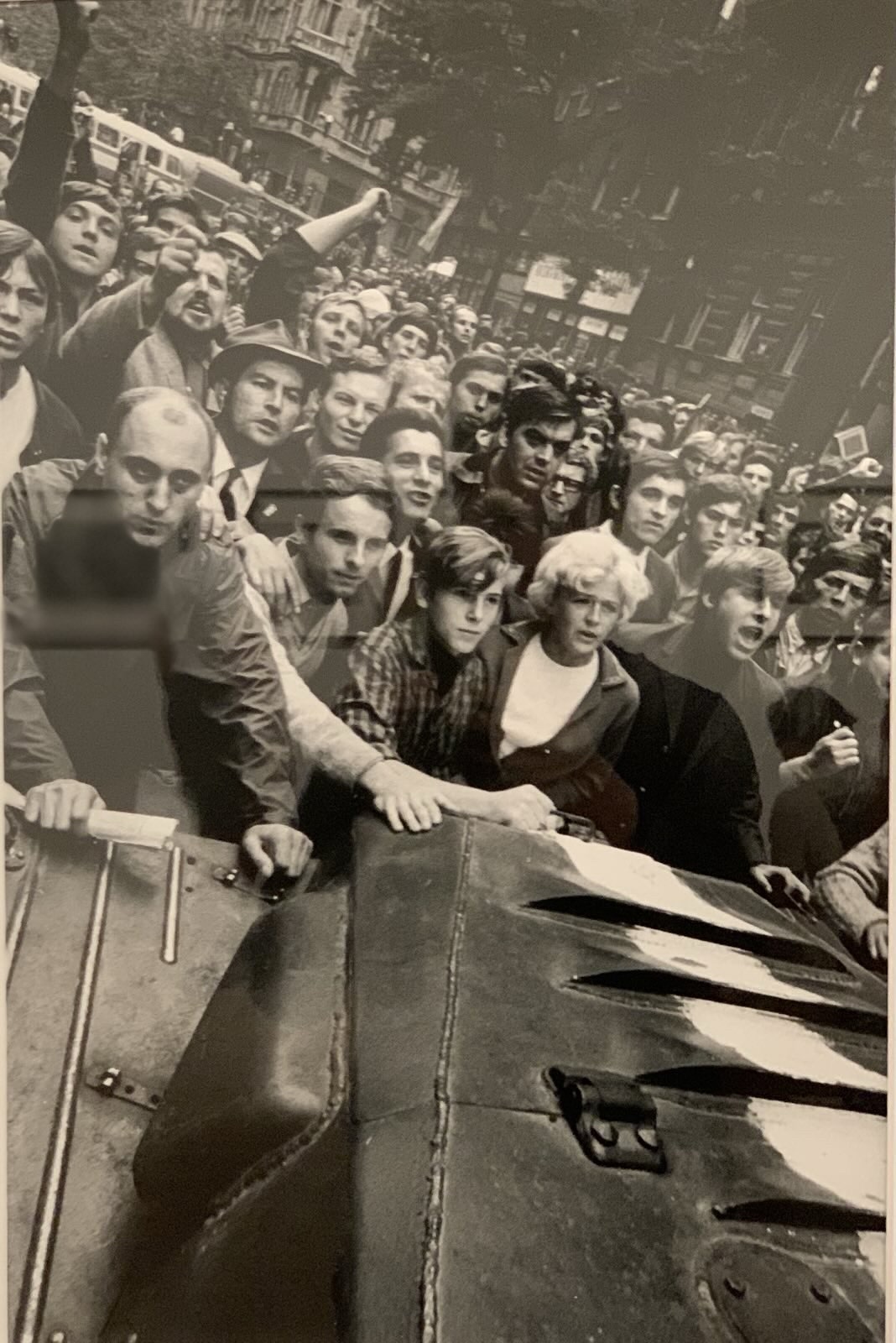 People crowd around a tank with soldiers 
