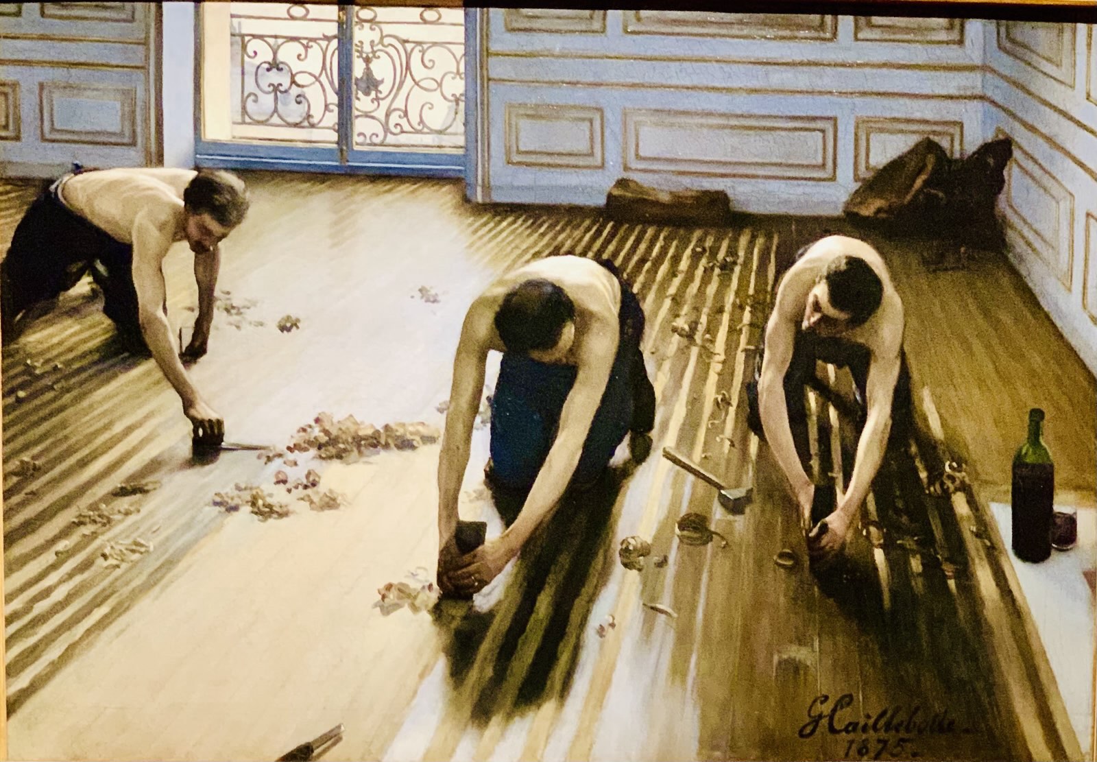 Photograph of an artwork with men laying floor tiles
