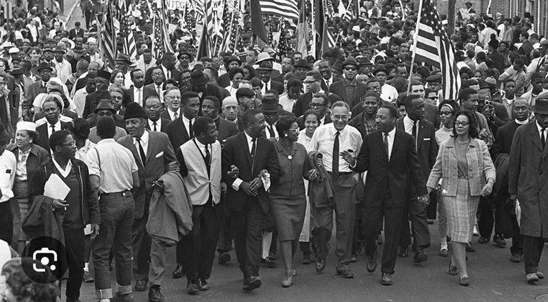 A black and white image of joyous solidarity among protestors at the height of the civil rights movement