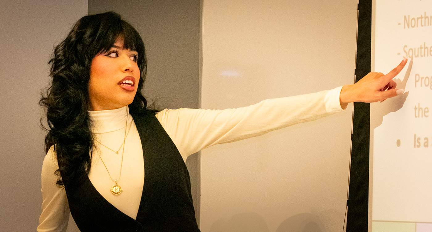 Young woman presenting at a lectern.
