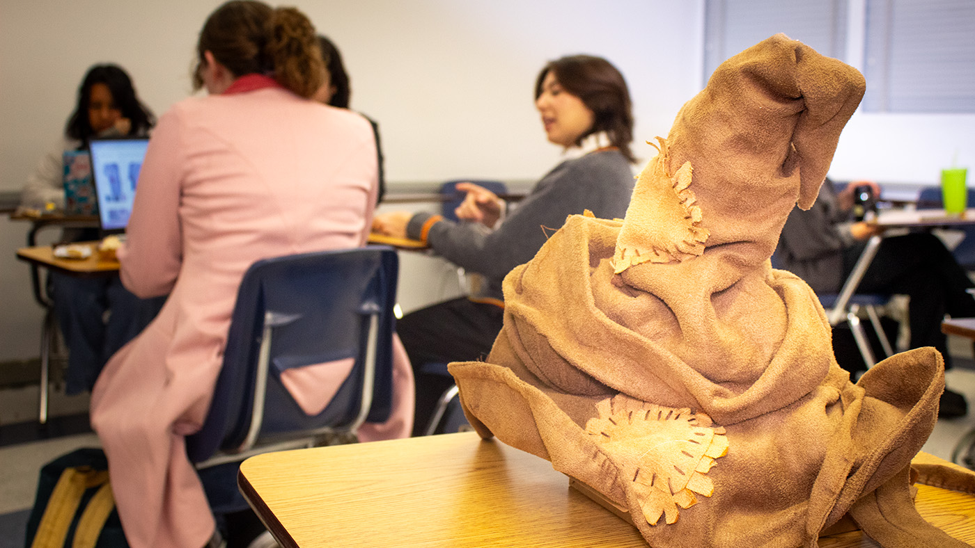 Sorting hat resting on a desk while students work in groups.