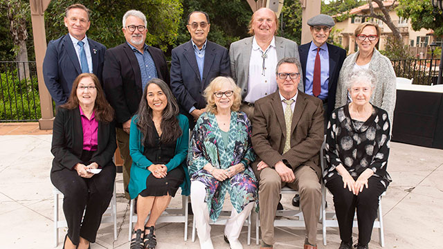 Two rows of retiring faculty smile