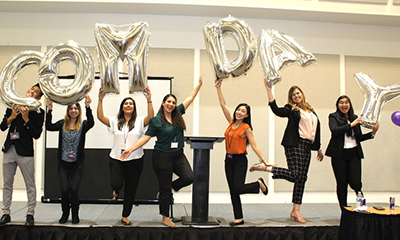 Students with Balloons that say Com Day