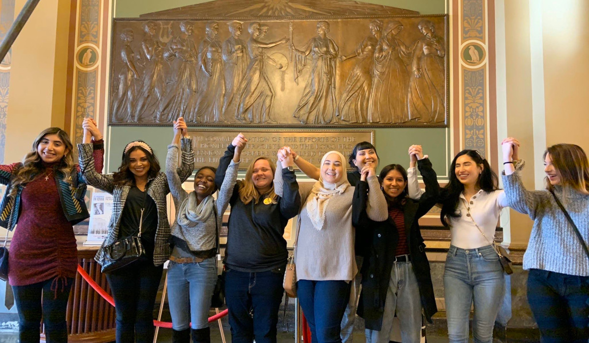 group of girls hands together up high
