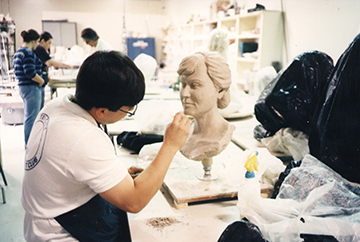 student sculpting a bust 