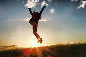 Person Jumping in Victory with sunset background