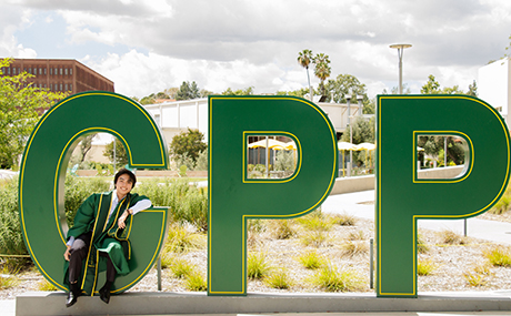 Stephen Ko sitting on CPP letters on campus