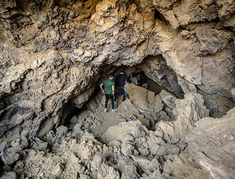 students walking into a cave