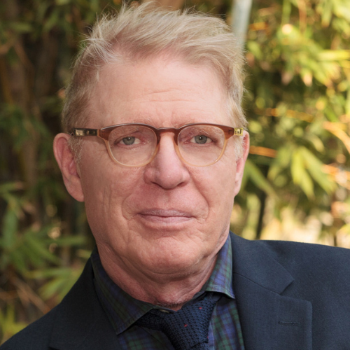 Music department chair Dr. Kopplin, wearing black glasses and a black suit.