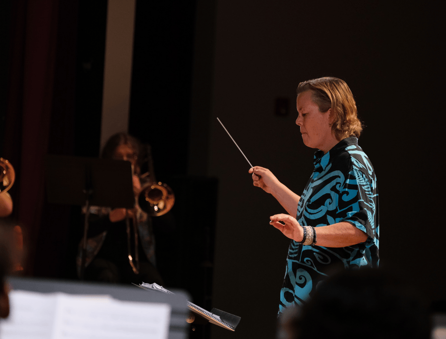 Dr. Lori Stuntz leads the Cal Poly Pomona Brass Ensemble during a performance, holding a baton and guiding the musicians.