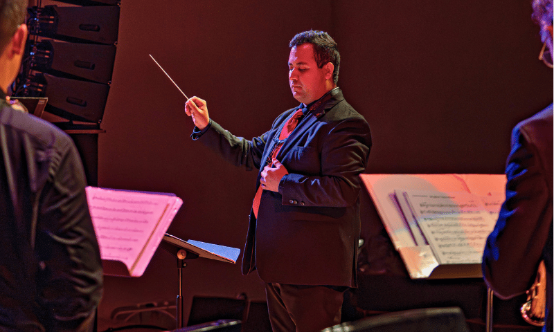 David Polanco conducting on stage during a performance.