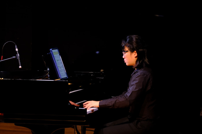 CPP music student performs on piano using a digital score during a live concert or recital.