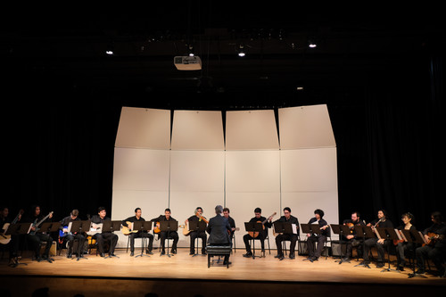CPP student guitar ensemble performs onstage under faculty direction in a formal concert setting.