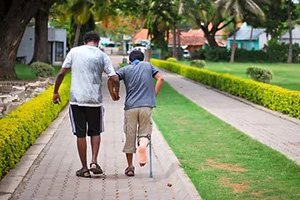 a student helping a kid on crutches