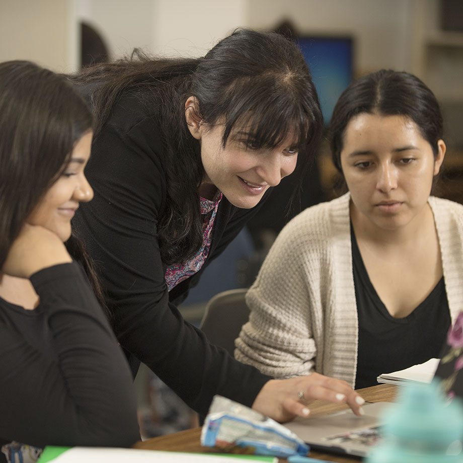 a faculty member engage in conversation during a small-group session.